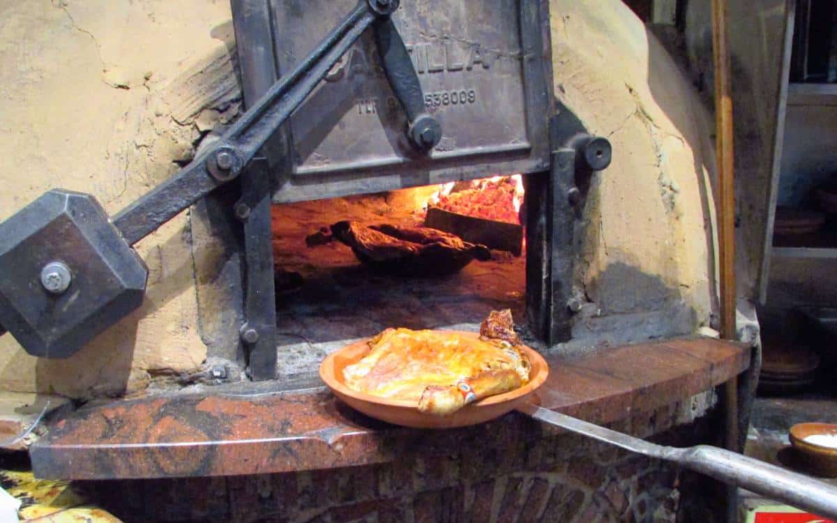 Preparación del lechazo asado en horno de piedra