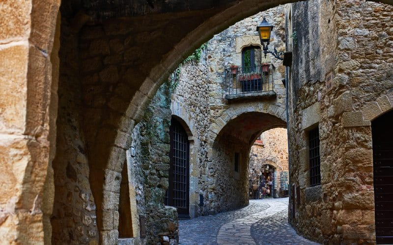 Una calle estrecha de piedra con arcos