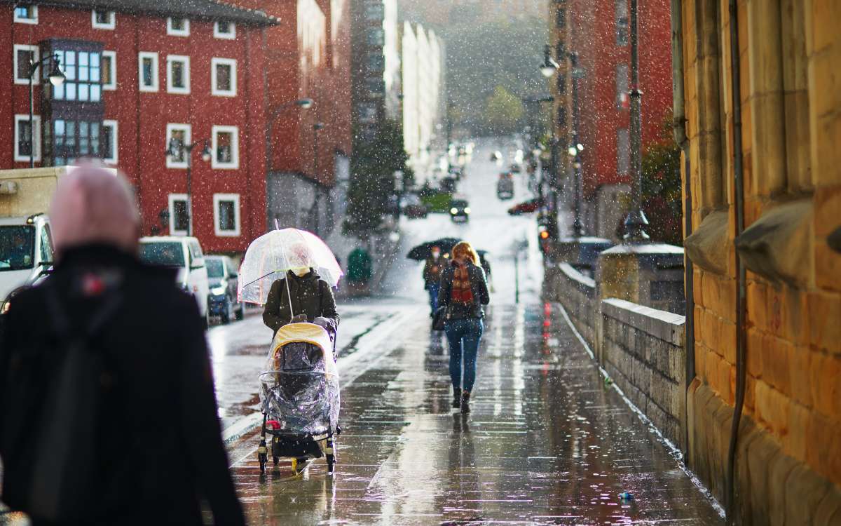 Gente caminando bajo la lluvia en una calle de Bilbao