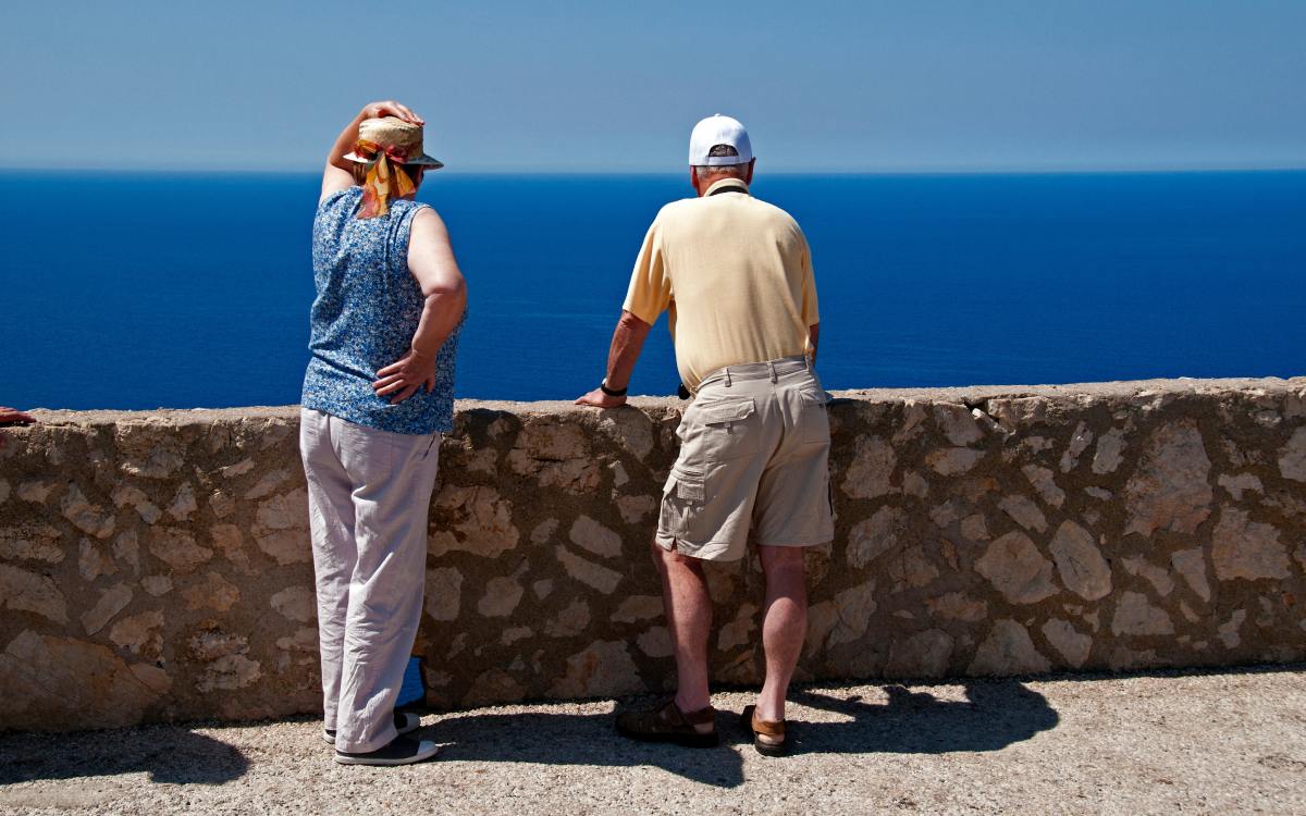 Turistas sénior contemplan el mar.