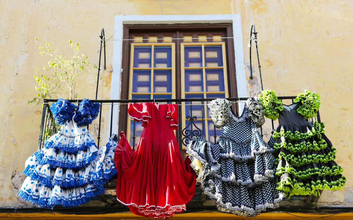 Trajes de flamenco tradicionales decoran un balcón de Málaga